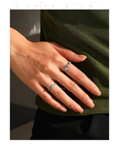 Detail of S925 sterling silver rings with turquoise stones worn on hand with shadow
