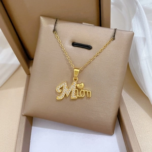 Close-up of golden Mama necklace with cubic zirconia pavé stones in jewelry box