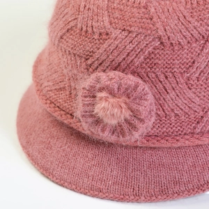 Detail of knitted women's hat featuring elegant floral accents and soft wool texture