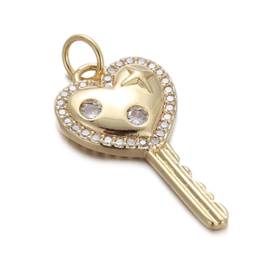 Macro view of gold heart key pendant with sparkling zircons for jewelry making