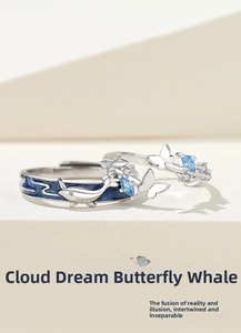 Close-up of whale and butterfly couple rings with blue enamel and zircon details