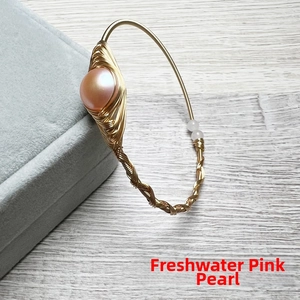 Close-up of a large pink freshwater pearl on 14K gold-filled wire-wrapped handmade bracelet
