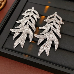 Close-up of vintage silver leaf earrings with shimmering full diamond pavé detailing