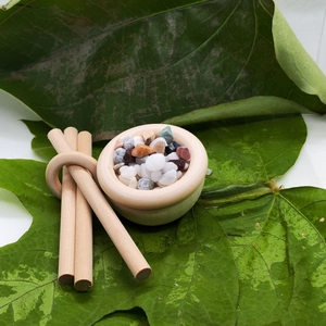 Natural wood essential oil diffuser set with colorful stones on green leaves