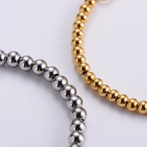 Macro shot of polished gold and silver titanium steel beaded bracelets showing detail