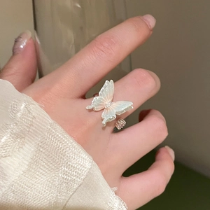 Detail of elegant butterfly open ring with iridescent wings and shimmering setting