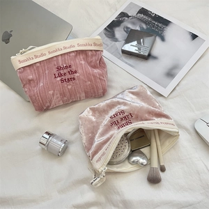 Flat lay of velvet makeup bags with Shine Like the Stars embroidery and storage space