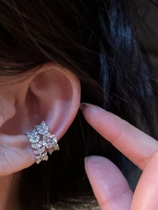 Close-up of elegant leaf-shaped silver ear cuff with sparkling pavé zircon stones