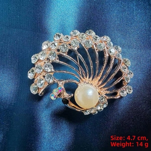 Detailed macro view of peacock brooch with crystals and a large white pearl center