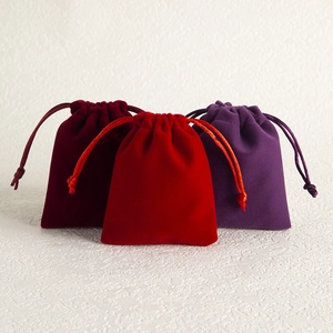 Three velvet drawstring jewelry gift bags in deep red, bright red, and purple colors