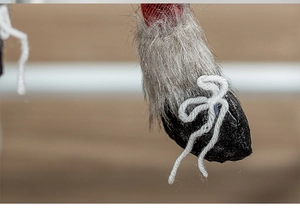 Macro detail of Nordic Christmas gnome with red plaid fabric and grey faux fur texture