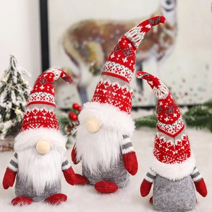 Three Christmas gnome plush dolls with knitted hats on white faux fur holiday display