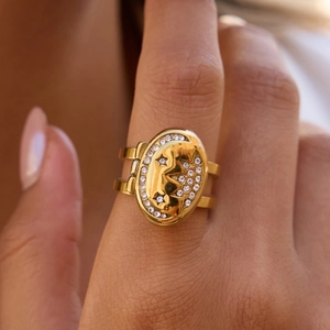 Macro shot of gold oval ring with celestial moon relief and sparkling zircon border