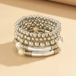 Close-up of multilayer stacked bracelets with silver beads and white pearls