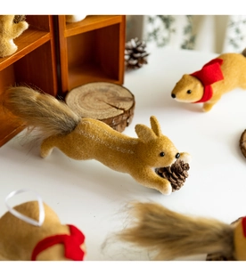 Detail of plush squirrel figurines with fluffy tails and pinecones for Christmas decor