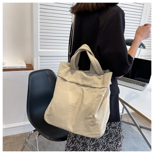 Close-up of lightweight off-white nylon tote bag showing fabric texture and shoulder strap