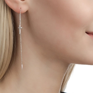 Close-up of S925 sterling silver cross earring with zircon on model's ear