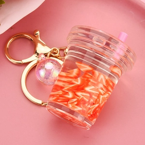 Detailed view of creative miniature milk tea cup keychain with fruit slices and liquid