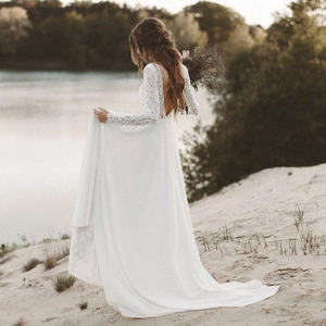 Elegant white lace long sleeve wedding dress with backless design and chiffon beach skirt