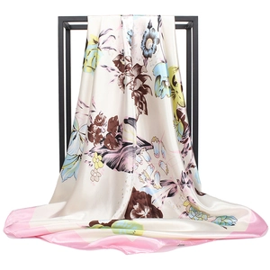 Ink wash floral print silk scarf with pink edges hanging on a minimalist metal stand