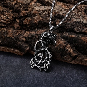 Détail du pendentif dragon viking avec nœud celtique sur écorce d'arbre