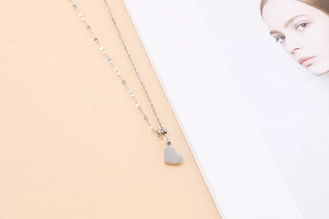 Detailed view of silver heart pendant necklace with shiny polished metal surface