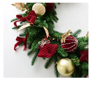 Detail of Christmas garland with velvet bows, golden leaves, and striped ornaments