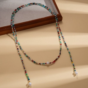 Colorful long beaded necklace with faux pearls on aesthetic warm beige layered steps