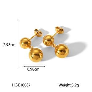 Macro detail of gold titanium steel earrings showing 2.98cm length and double ball design