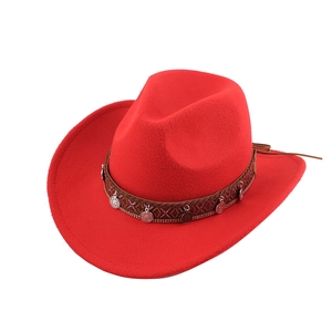 Detail of red cowboy hat with ethnic woven band and metallic coin charms decoration