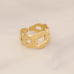 Macro view of adjustable gold chain link ring on minimalist marble background