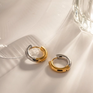 Detail of 4mm two-tone hoop earrings with a mix of 18k gold and silver finish on steel
