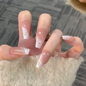 Detail of nude to white gradient ballerina nails with thin gold line patterns