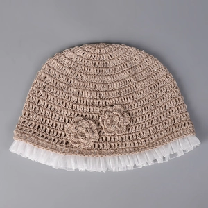 Detail of handmade crochet baby bucket hat with mesh lace trim and floral accents