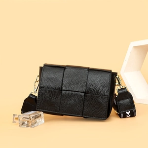 Premium black woven leather shoulder bag with wide strap and gold hardware on beige background