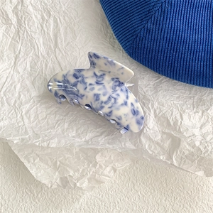 Close-up of elegant blue and white porcelain patterned acetate shark hair claw clip