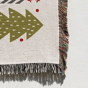 Detailed macro view of woven Christmas tree blanket with colorful fringe and cotton texture
