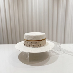 Detail of white wide-brim straw hat featuring rhinestone trim and elegant silk band