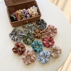 French vintage metallic silk scrunchies set in various shiny colors on a white table
