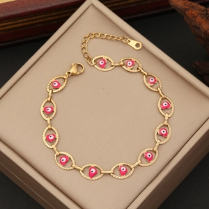 Detail of gold evil eye bracelet with pink hearts on a jewelry box lid