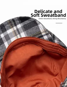 Detail of cotton sweatband and orange lining inside a plaid beret flat cap