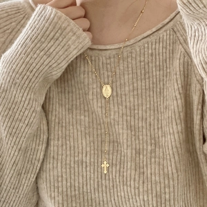 Close-up of a 925 silver golden rosary necklace with Mary medal and cross pendant