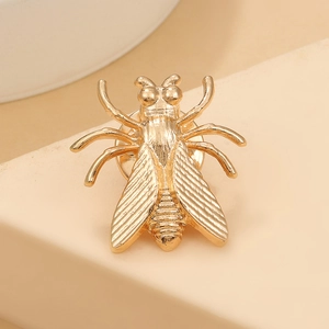 Macro detail of golden cicada insect brooch with intricate wing textures and pin back