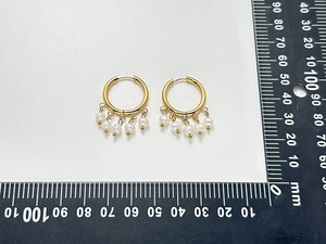 Detail view of 18K gold plated hoop earrings with five hanging natural freshwater pearls