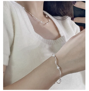 Detail shot of elegant freshwater pearl and silver curved tube necklace and bracelet set