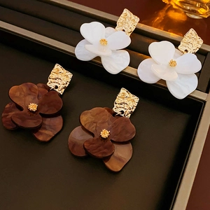 Detailansicht der Acryl-Blumenohrringe in Weiß und Schildpatt mit goldener Mitte