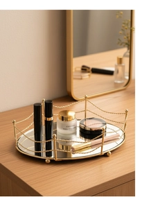 Detail of a luxury gold mirrored tray organizing cosmetics on a wooden tabletop