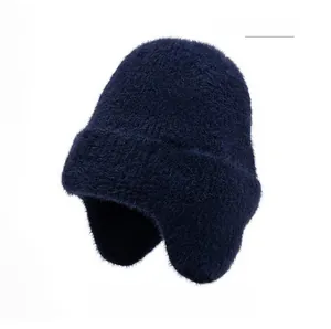 Détail du bonnet en tricot bleu marine avec fausse fourrure et écusson flocon de neige