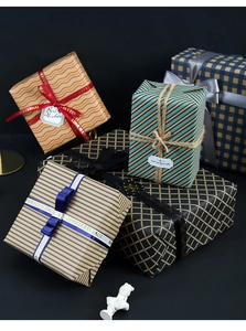 Detail of blue plaid kraft wrapping paper on gift boxes with ribbons and gift tags
