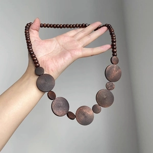 Bohemian geometric necklace with dark brown wooden beads and flat circular pendants